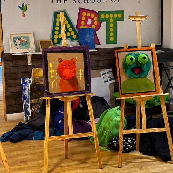 Children’s monster paintings on easels at a holiday art academy