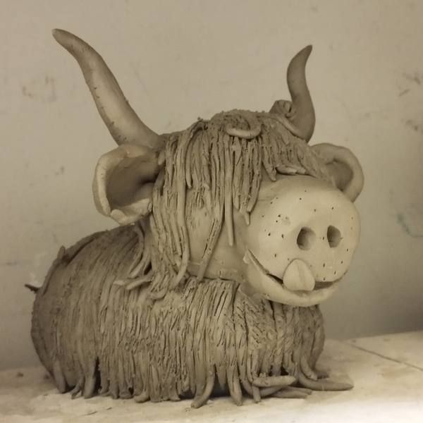A shaggy clay Highland Cow sculpture made in a workshop
