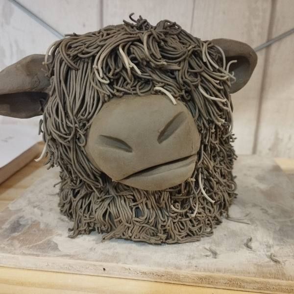 A shaggy clay Highland Cow face